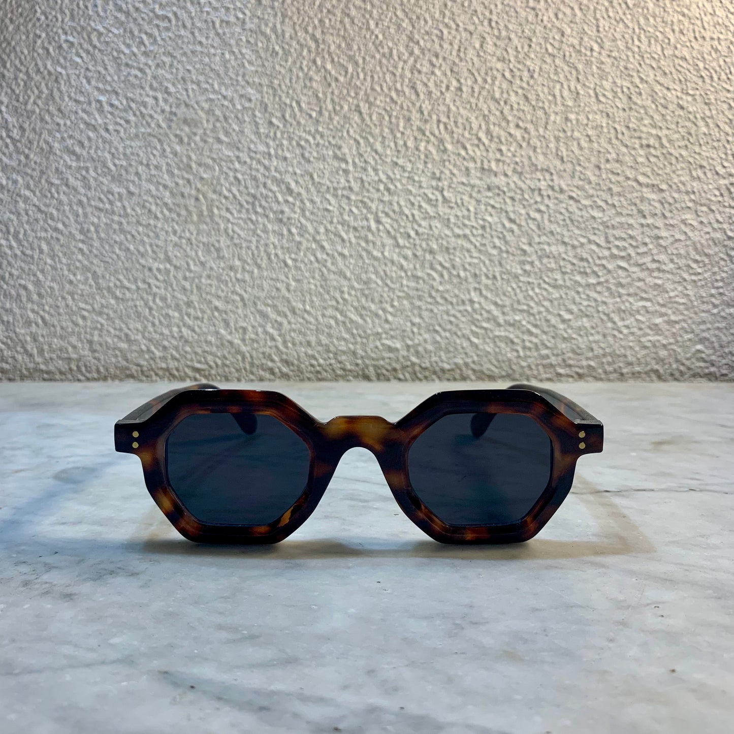 lunettes de soleil Pinigoon ecaille foncé la numero 11 sur buffet marbre