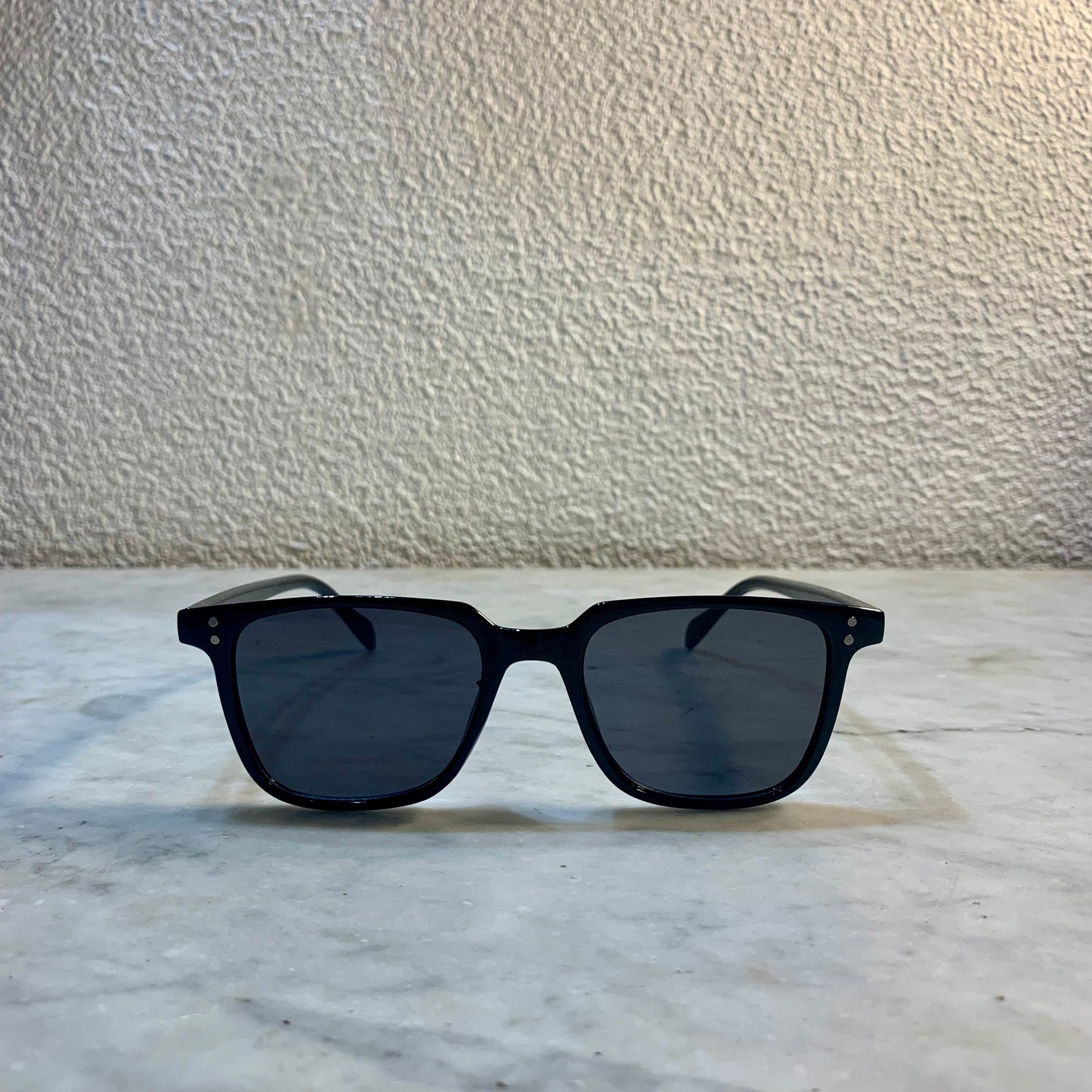 lunettes de soleil Pinigoon noir la numero 2 sur buffet marbre