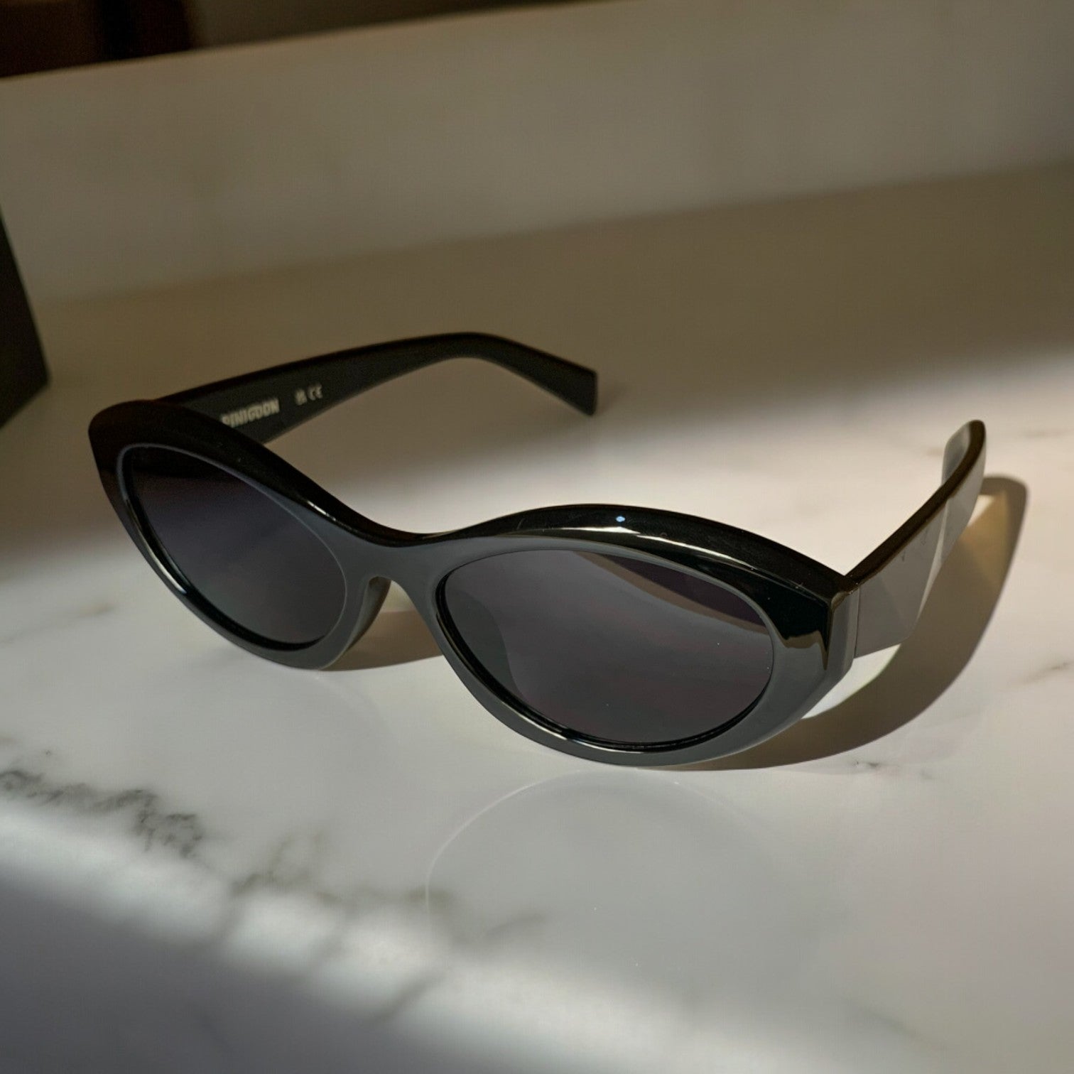 LUNETTES DE SOLEIL PINIGOON - LA NUMERO 19 NOIR SUR FOND MARBRE OUVERTES