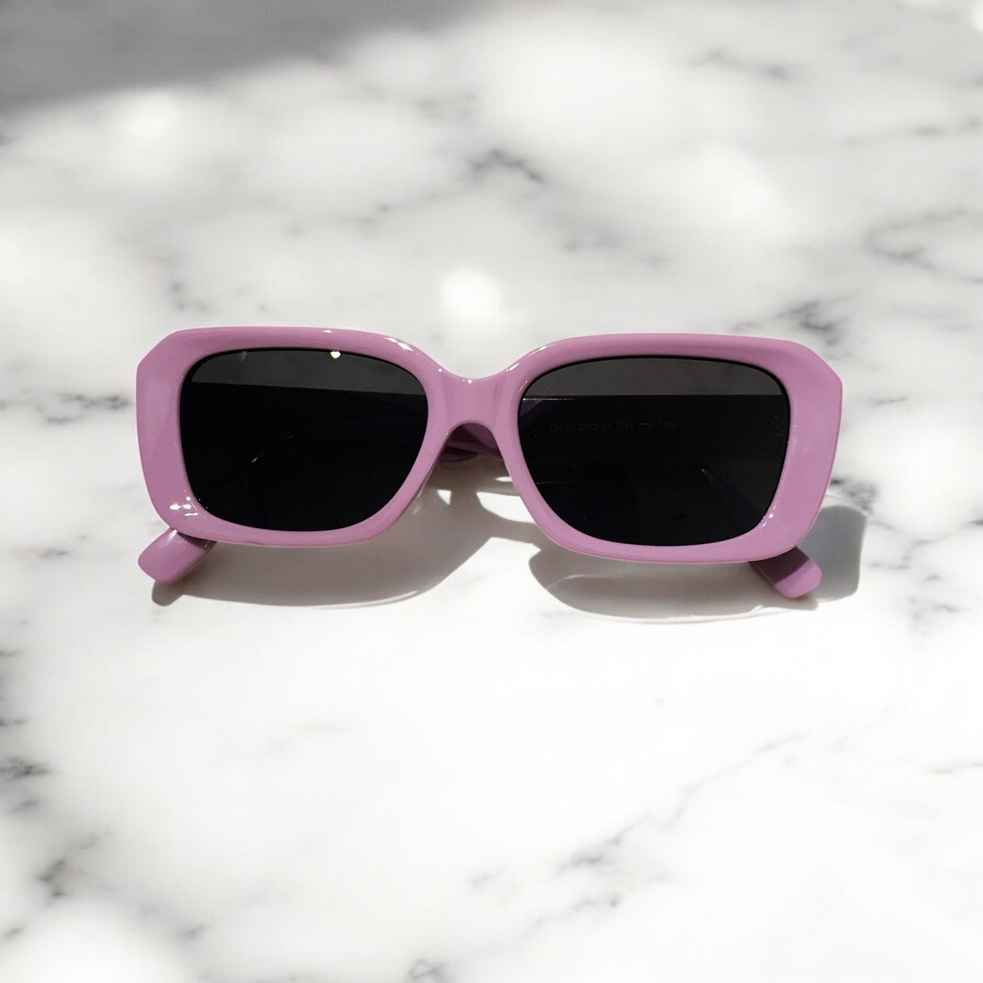LUNETTES DE SOLEIL rectangulaire femme PINIGOON LA NUMERO 24 VIOLETTE posée sur comptoir en marbre