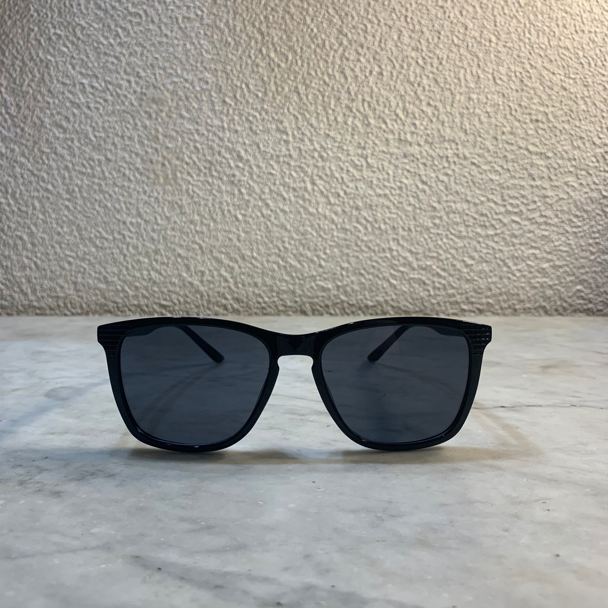 lunettes de soleil Pinigoon noir la numero 18 sur buffet marbre